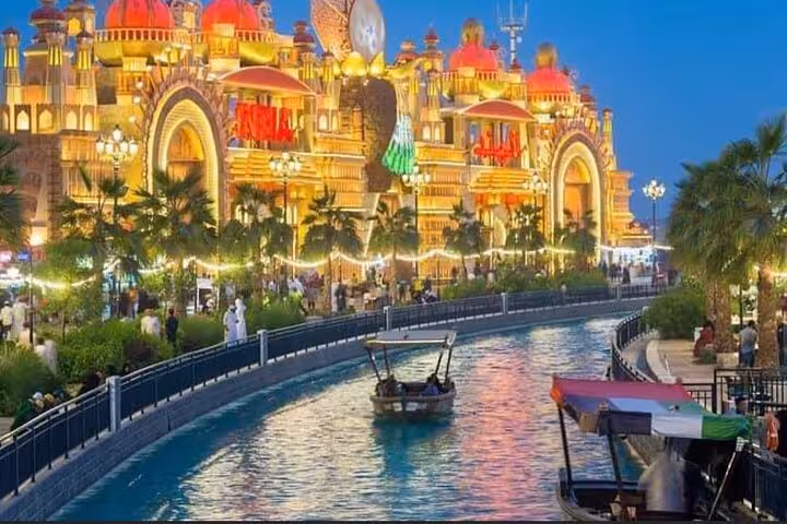 Global Village Dubai waterfront canal and illuminated pavilion at night on private tour with pickup