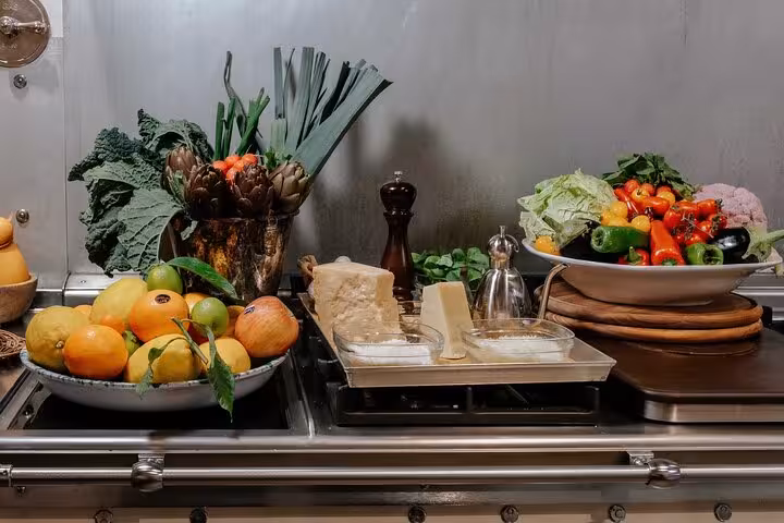 A vibrant assortment of fresh vegetables and cheeses arranged on a kitchen counter for a gluten-free Italian cooking class.