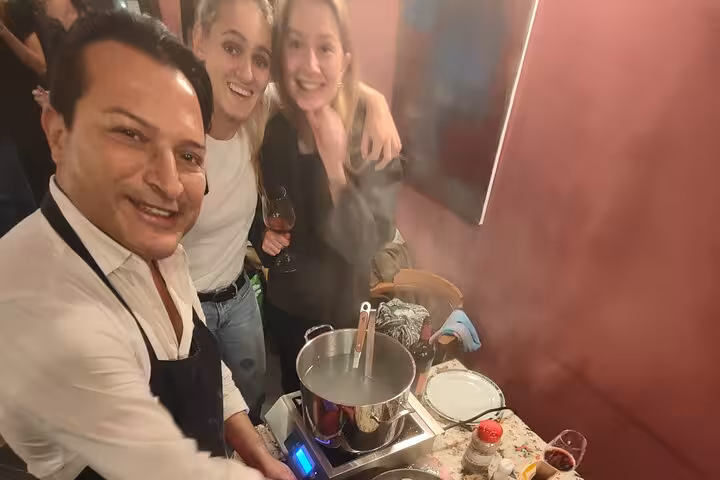 Chef and participants enjoying a gluten-free pasta cooking class in Rome, showcasing culinary skills and camaraderie.