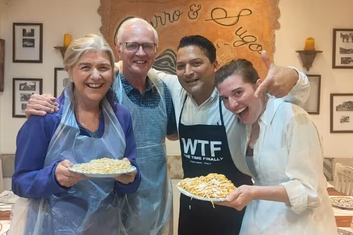Happy participants showcasing gluten-free pasta dishes at a cooking class in Rome.