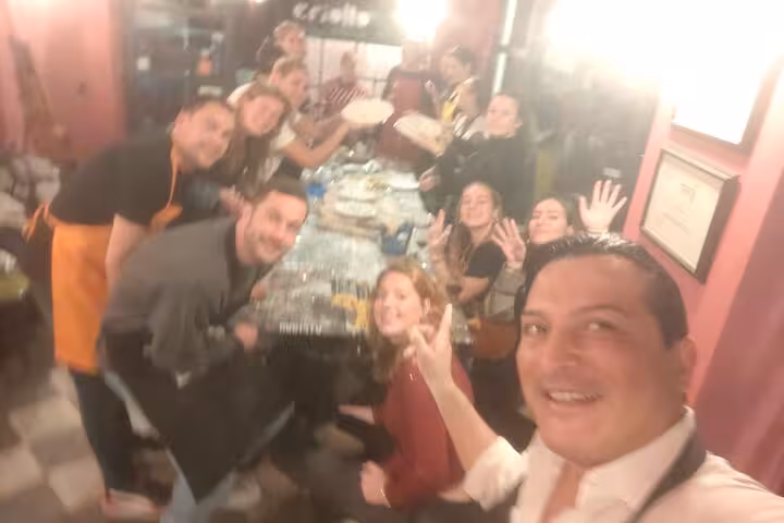 Group of enthusiastic participants at a gluten-free pasta course in Rome, posing with their culinary creations.
