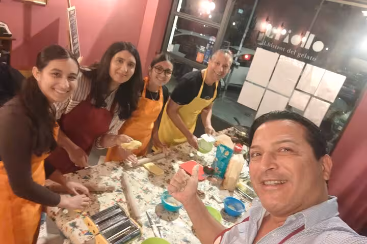 Group of five smiling participants in a gluten-free pasta course in Rome, learning to make three types of pasta.