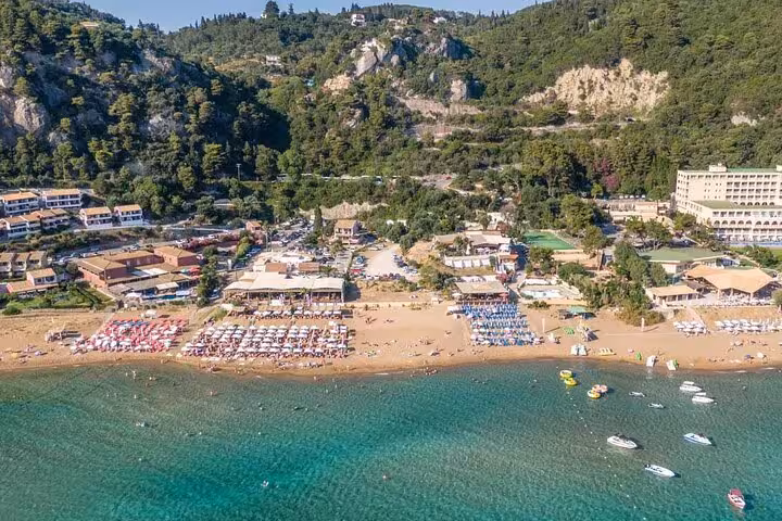 Aerial view of Glyfada Beach Corfu with sunbeds, beach bars and turquoise sea on a private beach tour