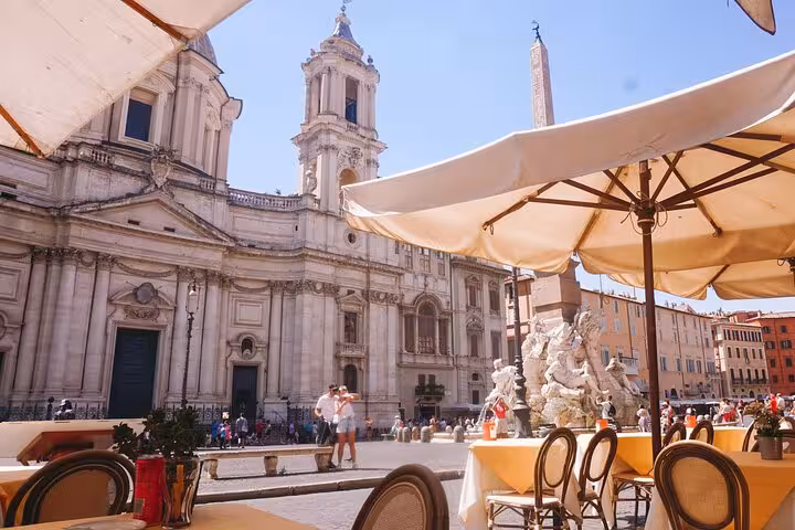 Outdoor cafe view of Piazza Navona with its iconic architecture, perfect for a Roman culinary experience.