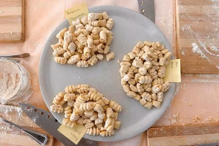 Freshly made gnocchi varieties labeled by participants on a plate during a hands-on cooking class near Piazza Navona, Rome.