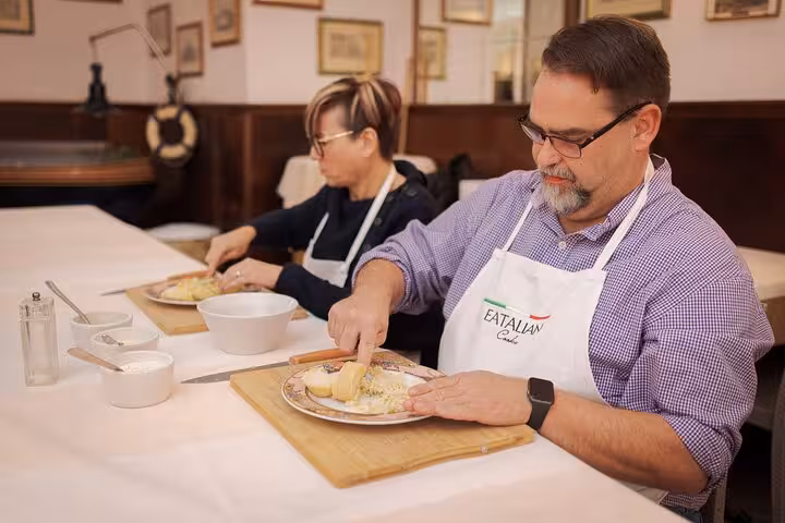 Two people enjoying a hands-on gnocchi-making experience at a cooking class in Rome's Piazza Navona area.