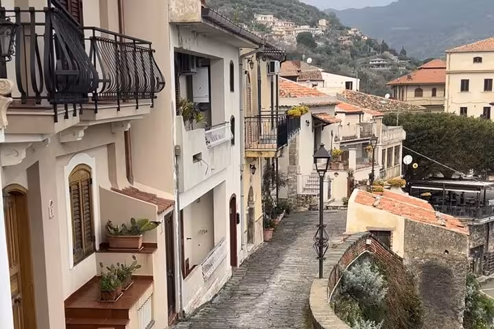 Charming narrow street in a Sicilian village with traditional houses and balconies, perfect for exploring Godfather locations.