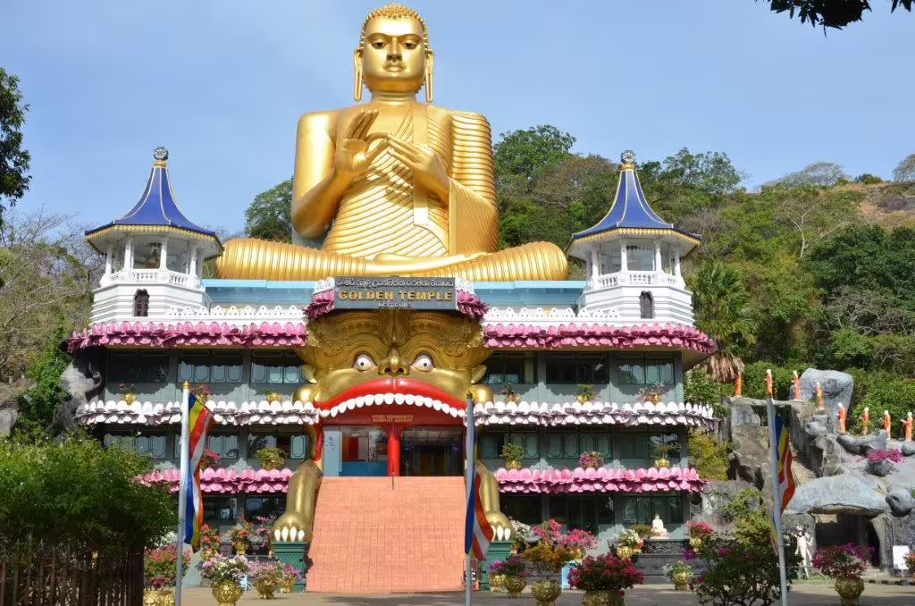 Majestic Golden Buddha statue at the entrance of Dambulla's Golden Temple, a UNESCO World Heritage Site in Sri Lanka.