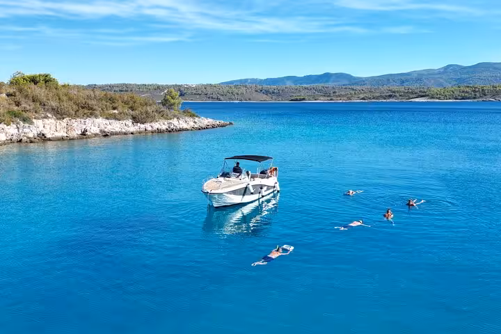 Boat anchored in calm blue sea with swimmers near Paklinski Islands, Hvar private tour to Golden Horn Beach