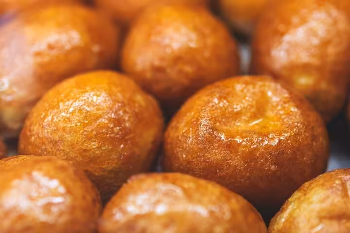 Golden loukoumades, traditional Greek honey doughnuts, glistening fresh and ready to enjoy on an Athens food tour.