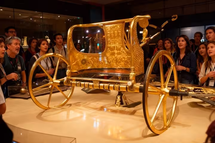 Golden royal chariot exhibit at the Grand Egyptian Museum on Sharm to Cairo air tour day trip