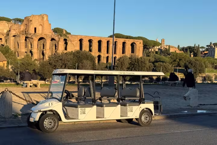 Golf cart parked by the Colosseum, highlight of Rome 1.5-hour historical city center sightseeing tour