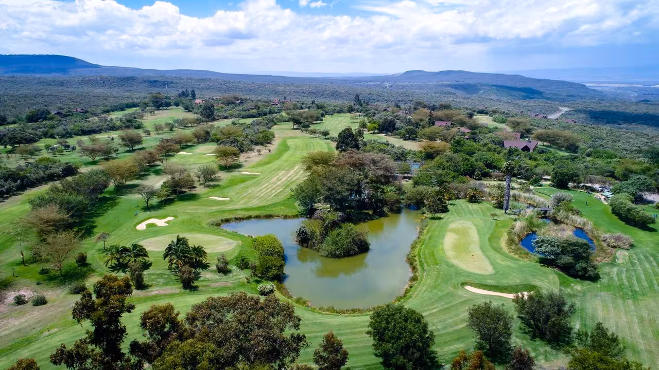 Expansive view of a vibrant golf course surrounded by natural beauty in the Great Rift Valley, ideal for golf and safari tours.