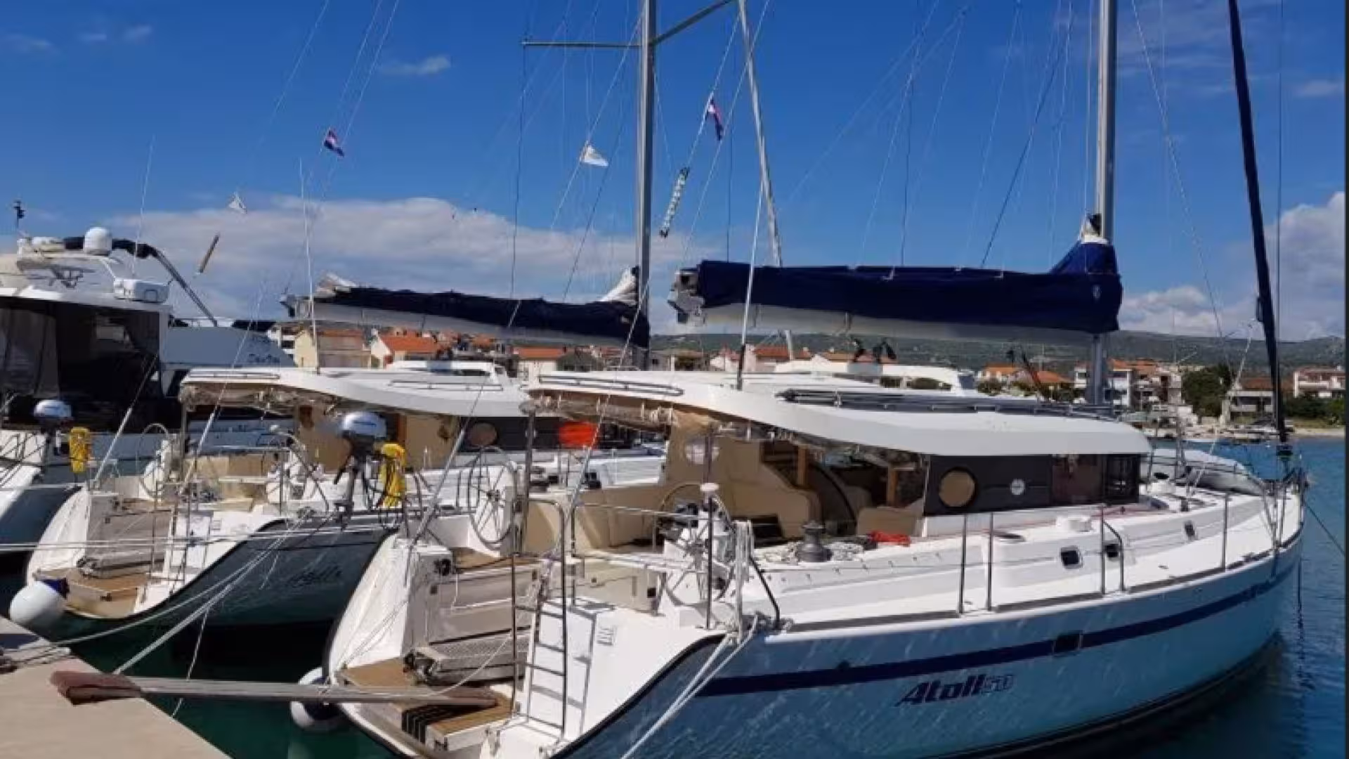 Docked sailboats ready for a Golfo Aranci excursion in Tavolara Marine Area under clear skies.