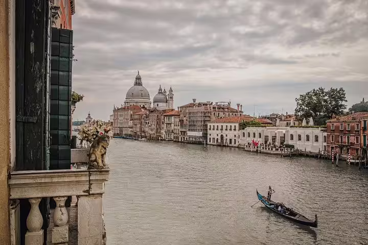 Scenic view of a gondola gliding along Venice's Grand Canal with iconic architecture in the background.