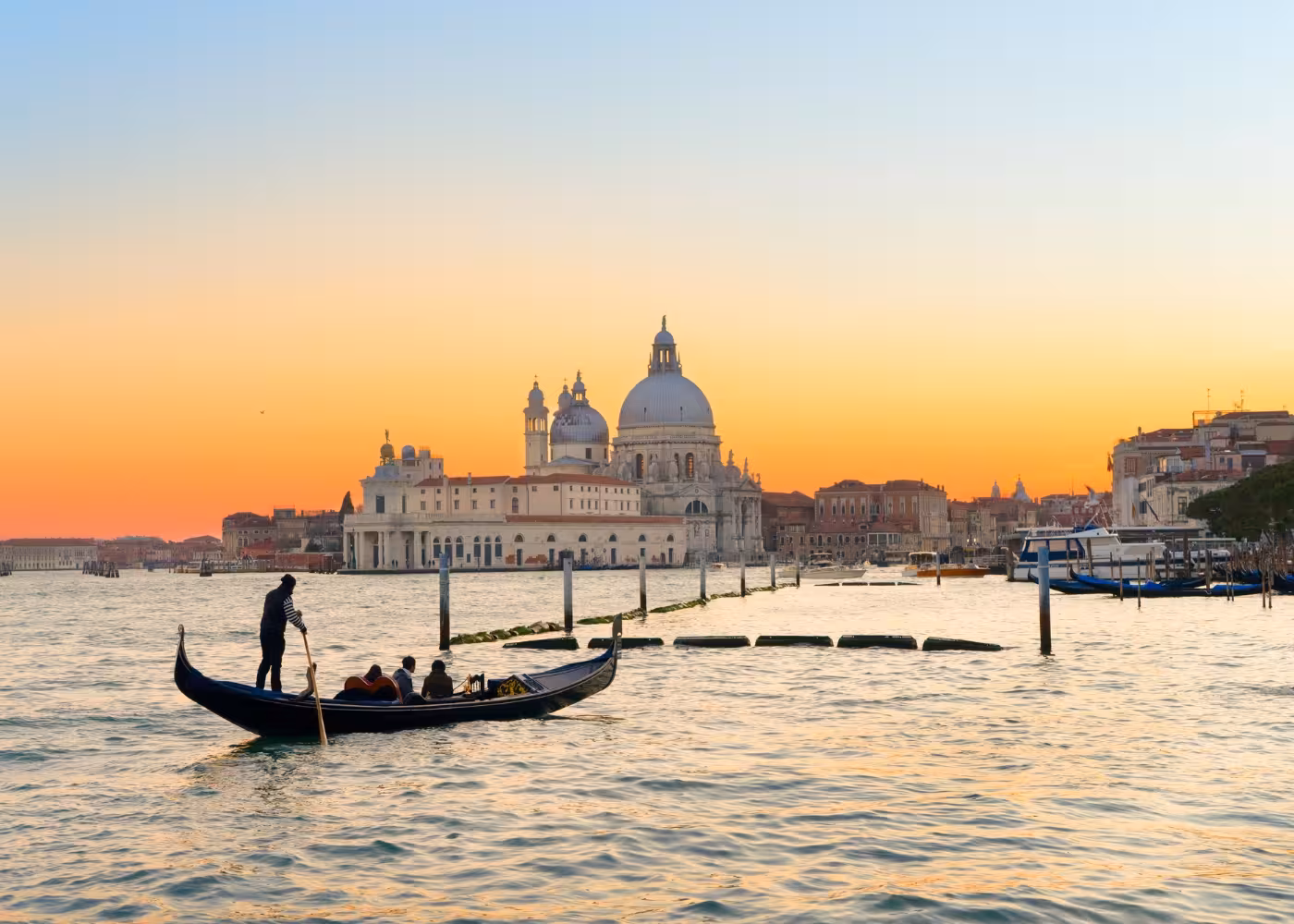 Gondola gliding on Venice's Grand Canal at sunset, offering a romantic experience with breathtaking views.