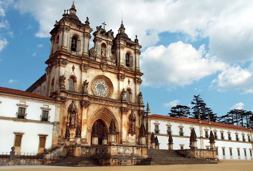Historic Gothic monastery facade under a blue sky in Northern Portugal, showcasing cultural heritage and architectural beauty.