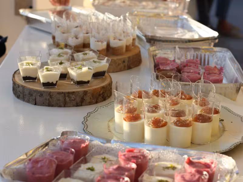 Assorted gourmet desserts in elegant cups displayed on a table for a private event catering experience.
