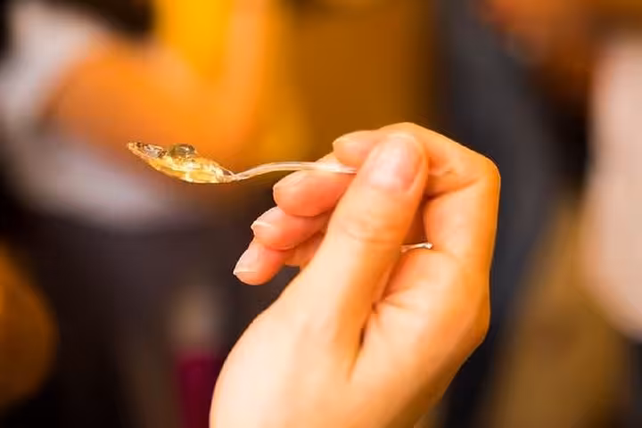Close-up of a hand holding a spoon of gourmet jam on the Saint-Germain chocolate and pastries tour.