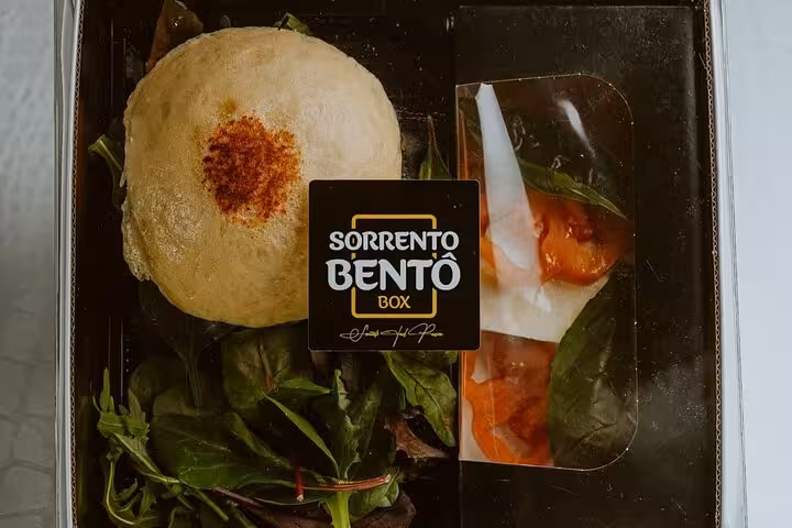 Gourmet Sorrento Bento Box with fresh greens and tomatoes, perfect for a private Amalfi Coast boat tour.