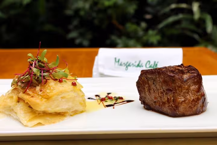 Gourmet steak with layered potato gratin served at an authentic Brazilian diner with live music experience.