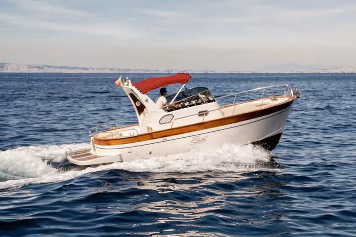 Typical Gozzo 750 boat cruising on the blue waters of the Mediterranean, ideal for a private Sorrento to Amalfi tour.