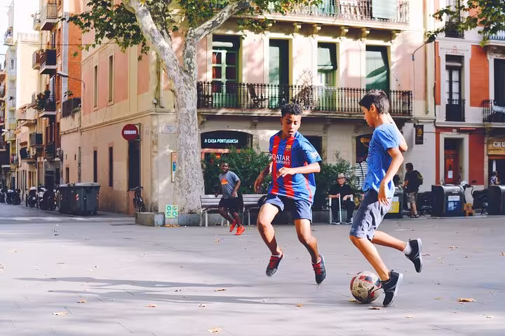 Local kids playing soccer in a Gràcia plaza, Barcelona, on a small group Catalan culture and cuisine tour
