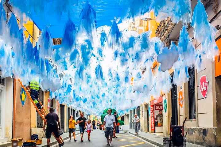 Colorful Gràcia street with blue festival decorations, a highlight on the Catalan culture and cuisine small group tour