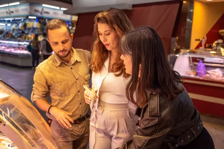 Food market stop on Gràcia neighborhood tour in Barcelona, sampling local bites with vermouth tasting