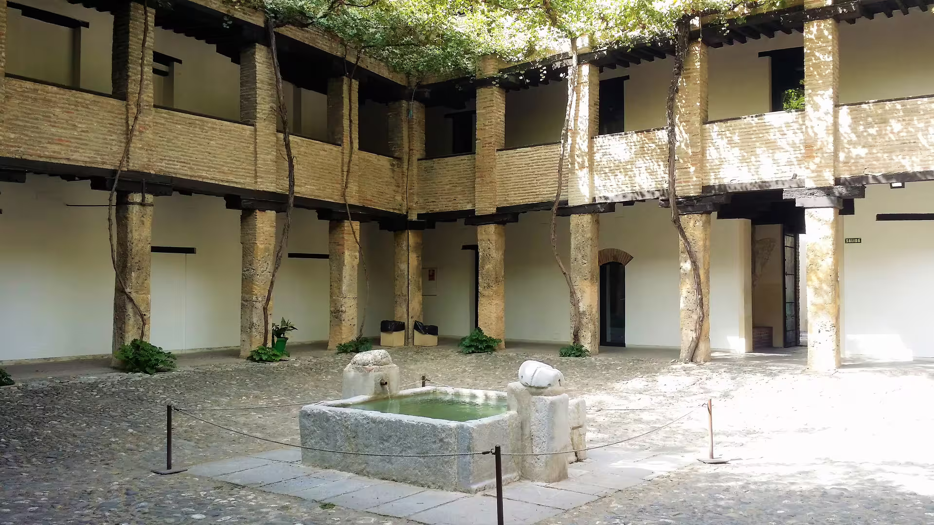 Quiet courtyard with stone fountain in Granada, seen on Alhambra group day trip with Costa del Sol hotel pick-up