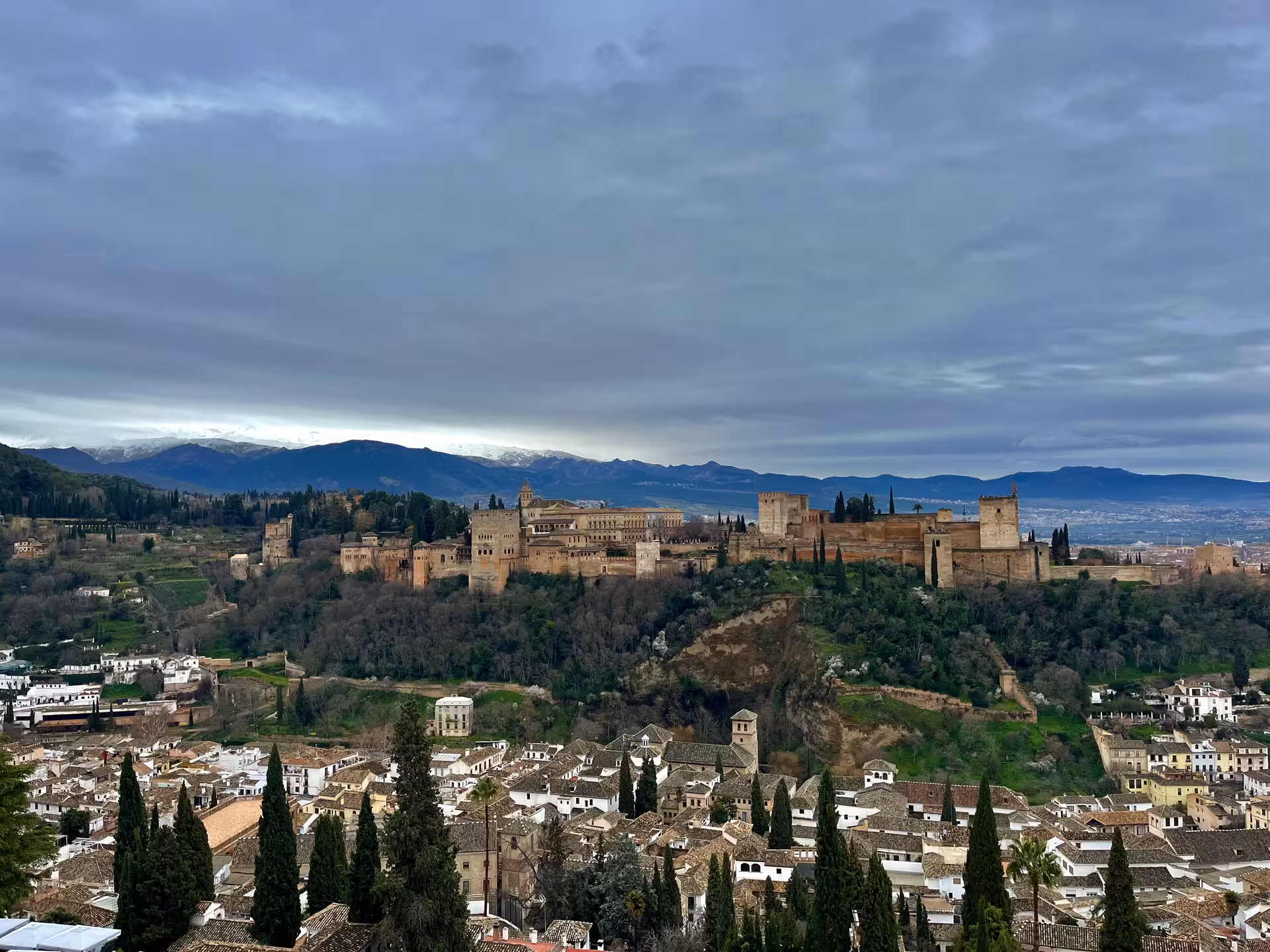 Panoramic view of Granada with the Alhambra fortress, Albaicín rooftops and Sierra Nevada on Encantos Locales tour
