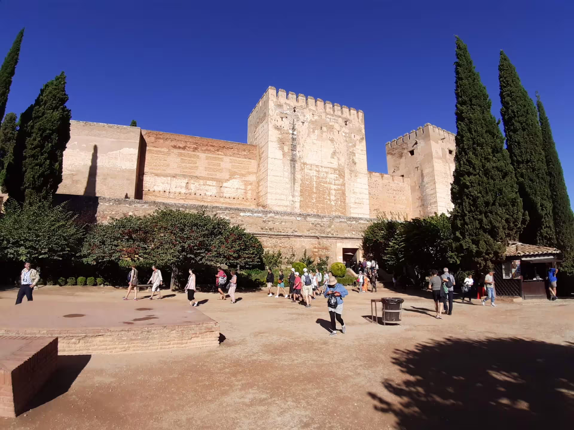 Visitors gather outside the Alhambra fortress walls in Granada on a group day trip from Costa del Sol