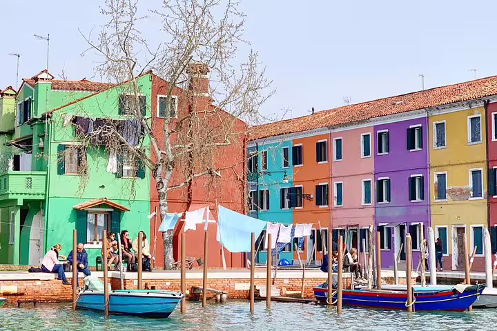 Vibrant houses and boats along Burano's canal, perfect for a Grand Canal Boat Private Tour to Murano and Burano.
