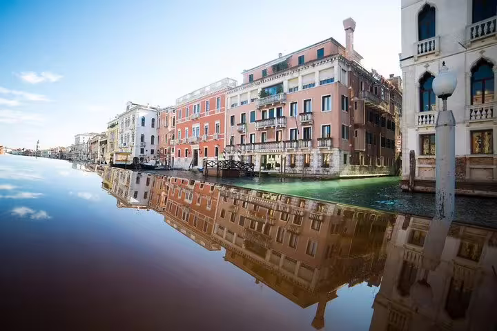 Scenic view of colorful Venetian buildings reflecting on the Grand Canal during a serene boat tour.