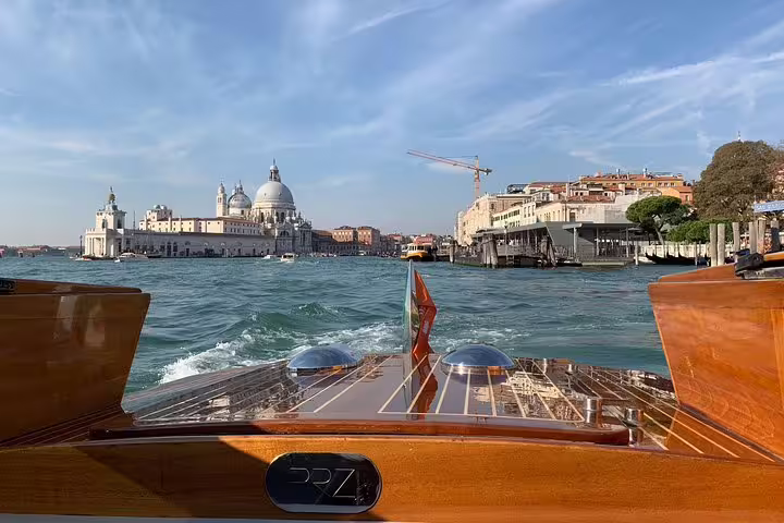 View from a private boat tour on the Grand Canal, showcasing Venice's stunning architecture under a clear blue sky.