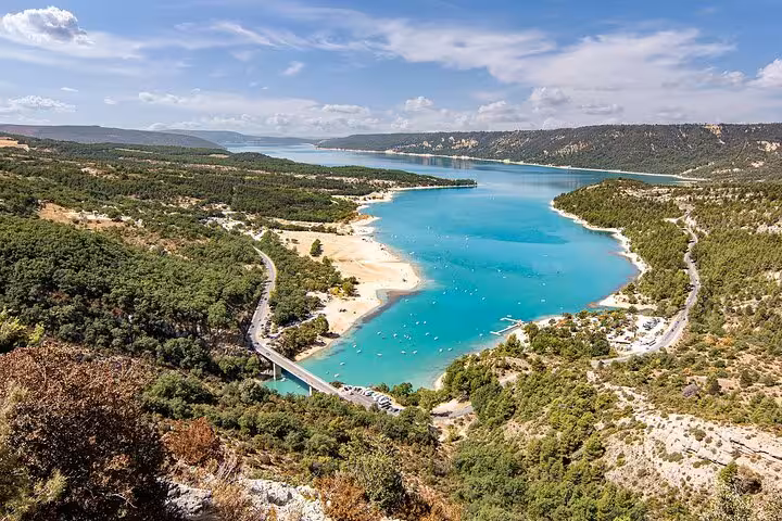 Scenic view of turquoise lake surrounded by lush greenery in the Grand Canyon of Europe on a sunny day.