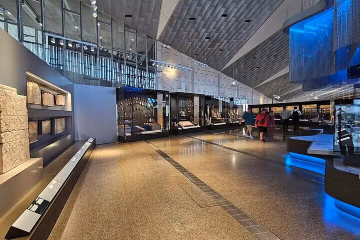Inside the Grand Egyptian Museum galleries with ancient artifacts displays, included in VIP Giza & GEM Tour Cairo