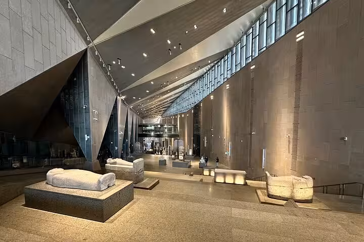 Grand Egyptian Museum interior gallery with ancient stone artifacts, part of VIP Giza & GEM tour itinerary