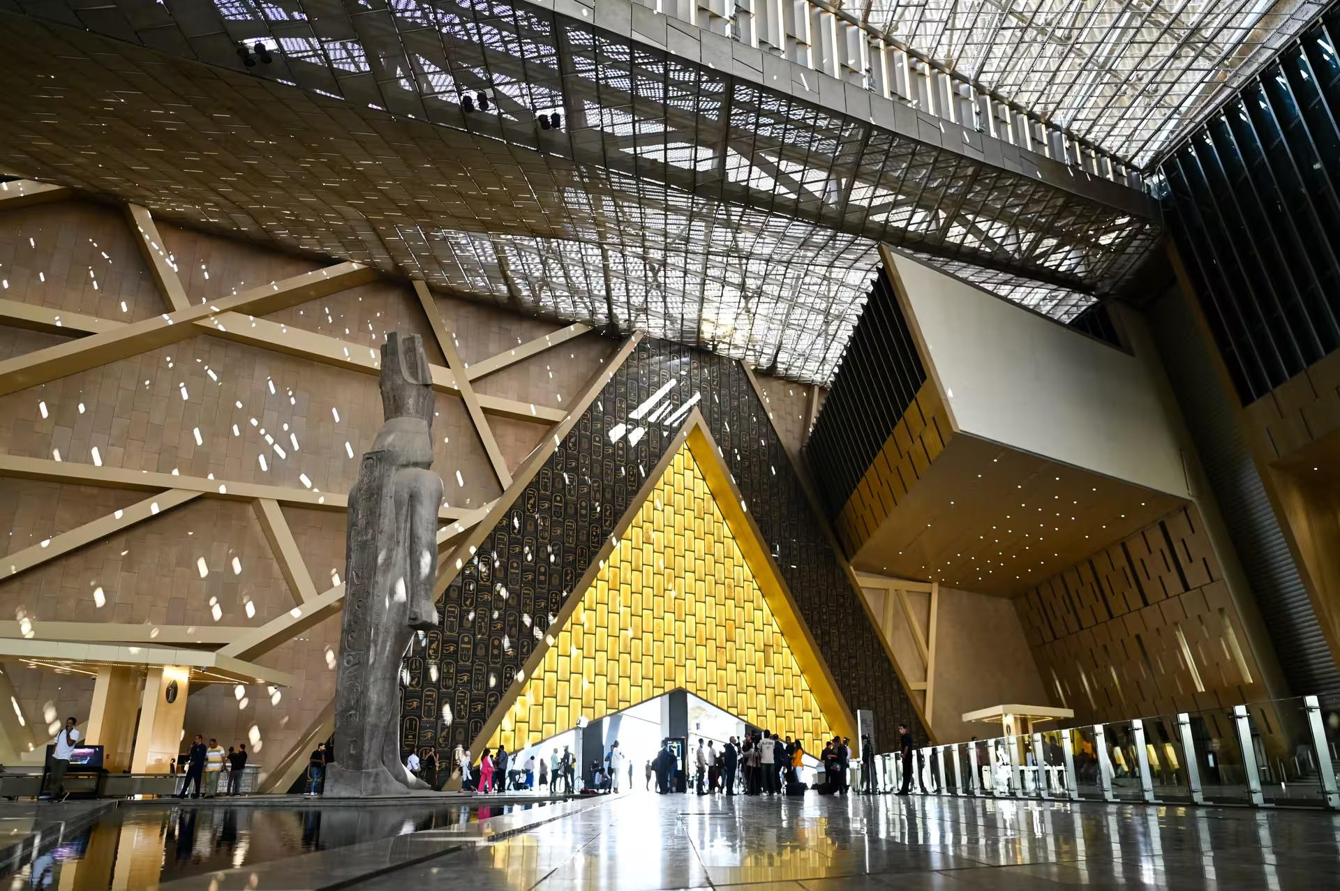 Grand Egyptian Museum atrium in Giza with towering statue and golden entrance on private 4-day Cairo tour
