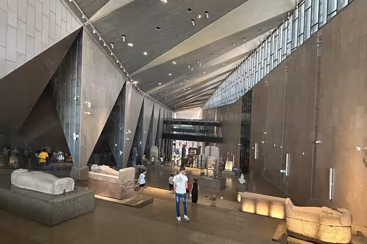 Grand Egyptian Museum atrium in Giza with monumental statue and golden pyramid entry on guided tour