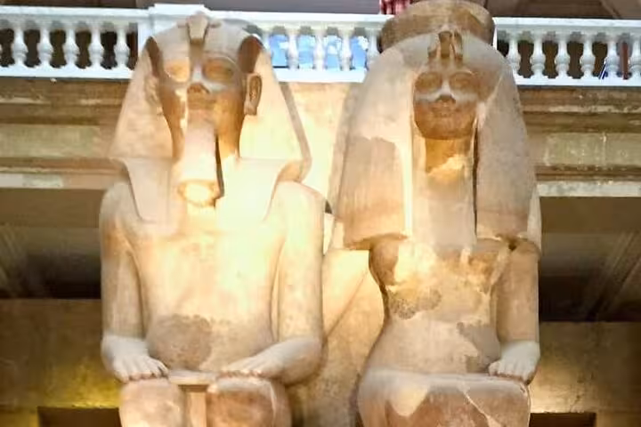 Colossal seated pharaoh statues inside the Grand Egyptian Museum on a private Giza pyramids and Sphinx tour