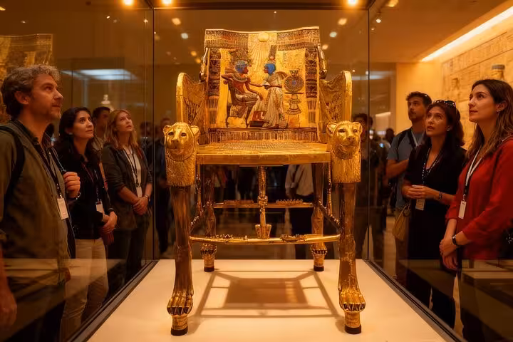 Visitors admire a golden pharaonic throne exhibit at the Grand Egyptian Museum on a Cairo day tour from Sharm