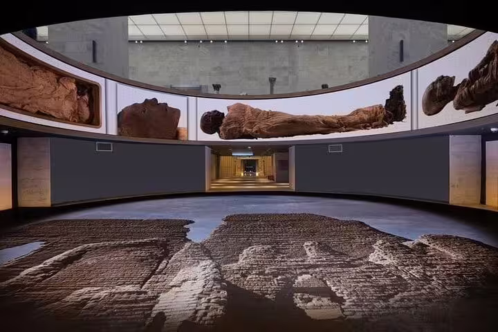 Grand Egyptian Museum gallery with ancient artifacts on private Port Said to Giza tour in Cairo