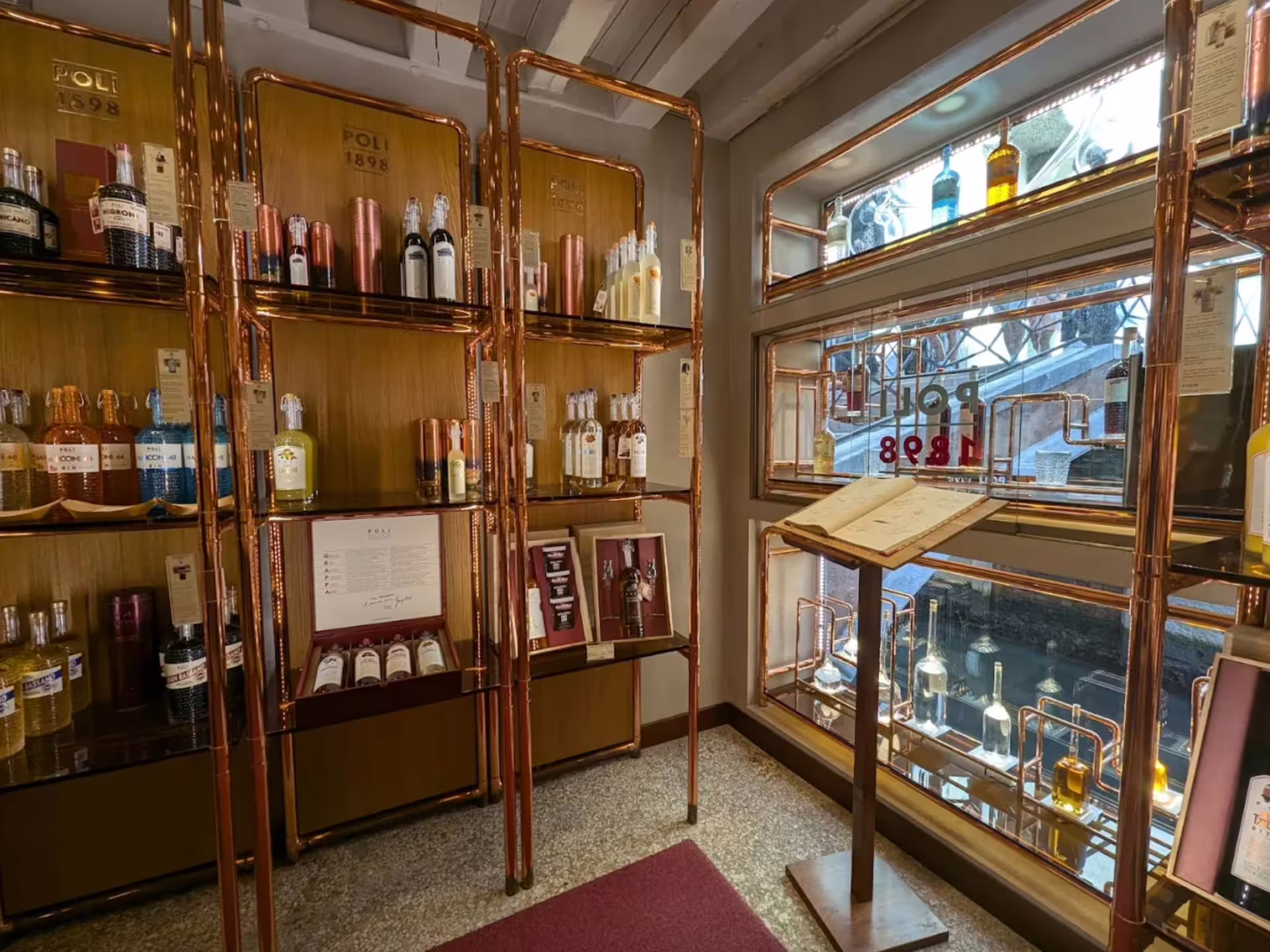 Elegant grappa display inside a Venetian tasting room, showcasing a variety of premium spirits on wooden shelves.