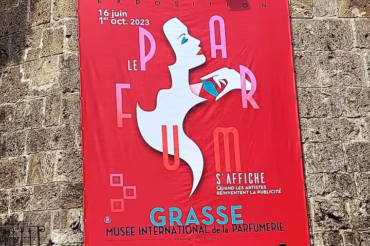 Vibrant red poster for Grasse's Musée International de la Parfumerie exhibition, Côte d'Azur discovery tour.