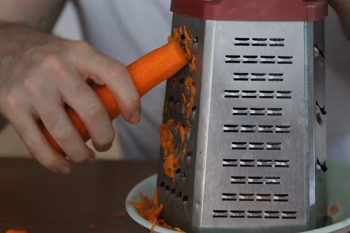 Close-up of grating carrot for Turkish meze recipes during beginner-friendly Istanbul cooking workshop