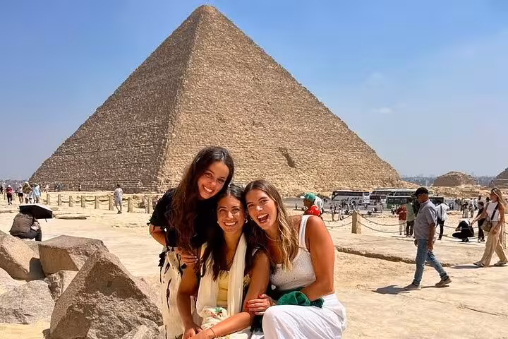 Friends posing at the Great Pyramid of Giza during a Cairo day tour to Giza Pyramids, Saqqara and Memphis