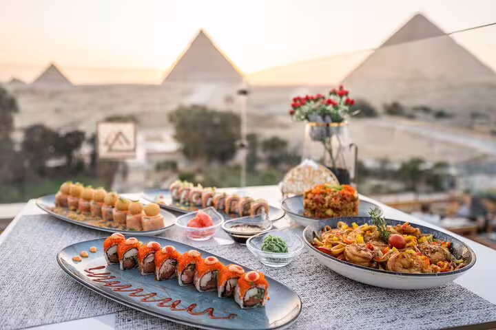 Great Pyramid Inn rooftop dinner with sushi and hot dishes overlooking Giza Pyramids at sunset on tour