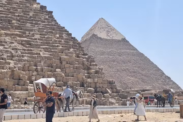 Tourists by the Great Pyramids of Giza with horse carriage, Cairo day trip from Sharm El Sheikh by bus