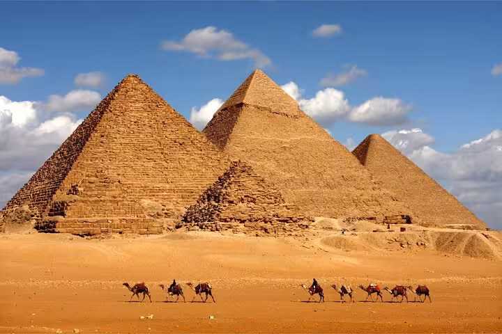 Wide view of the Great Pyramids of Giza with camel riders, Cairo bus tour from Sharm El Sheikh